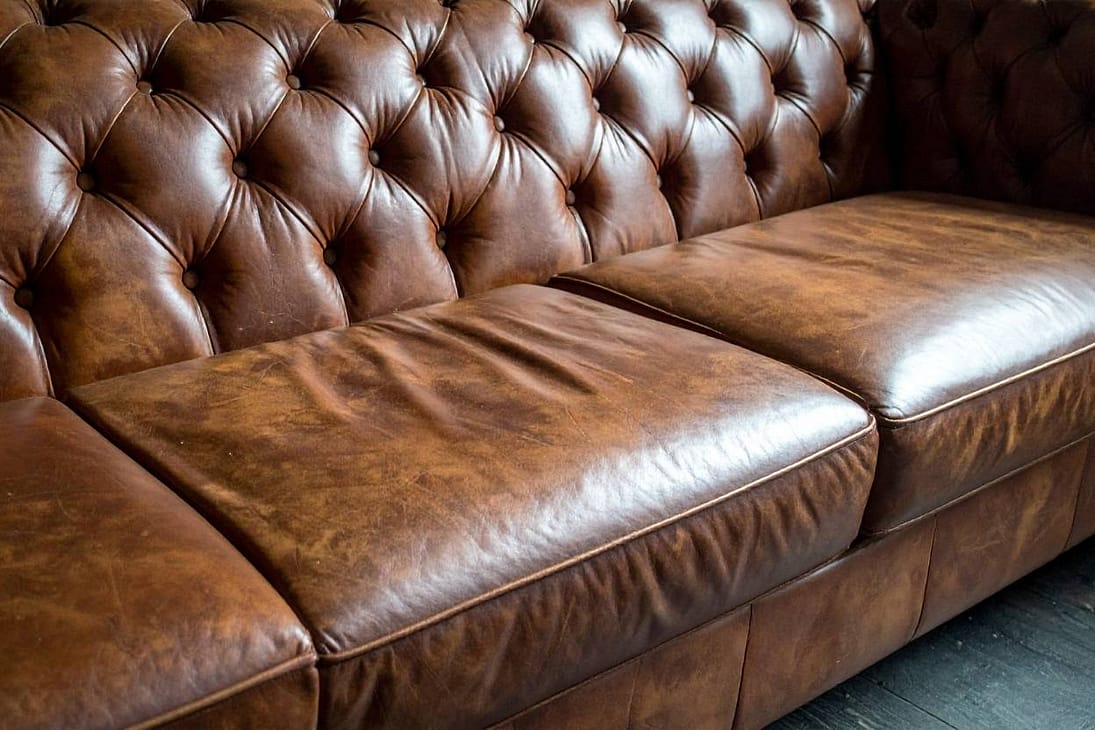 Luxury Home Decor Hands smoothing conditioner on tan leather armchair for restored shine.